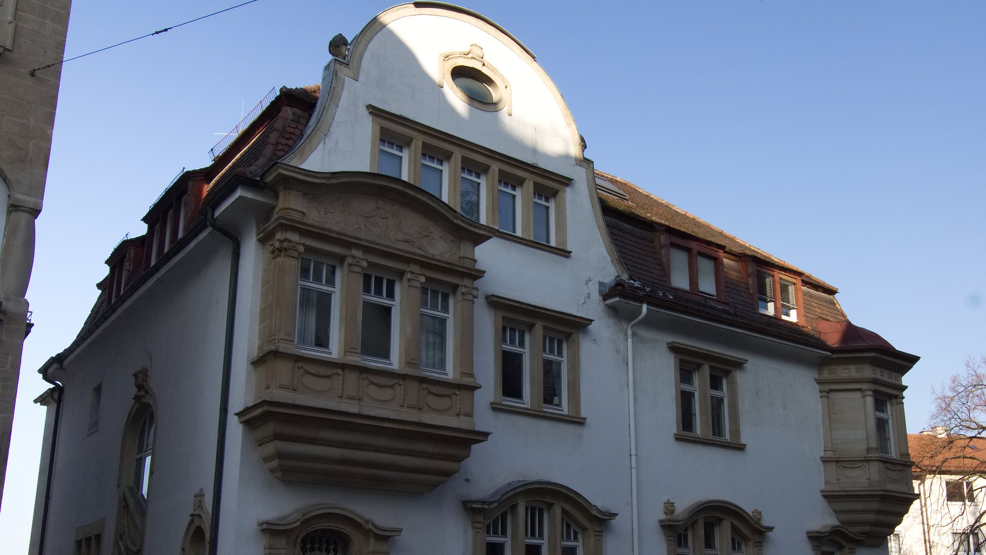 Mehrfamilienhaus mit geschwungenem Giebel in der Alexanderstraße in Stuttgart, von der Straße aus nach oben fotografiert